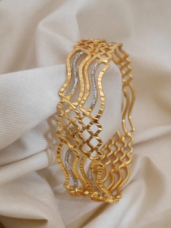 Gold bangles set with intricate designs